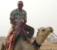 Economist Richard Akresh astride a camel during a recent visit to Burkina Faso.