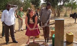 Sociology and psychology student Erin Woods tries out a pump in a village in Burkina Faso as part of an LAS Course Abroad.