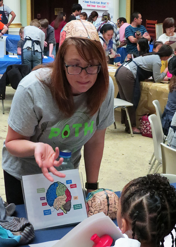 Linda Steinberg, a research coordinator at Illinois, speaks with a child during Brain Awareness Day near campus. (Photo by Ashley Lawrence, IHSI at Illinois.) 