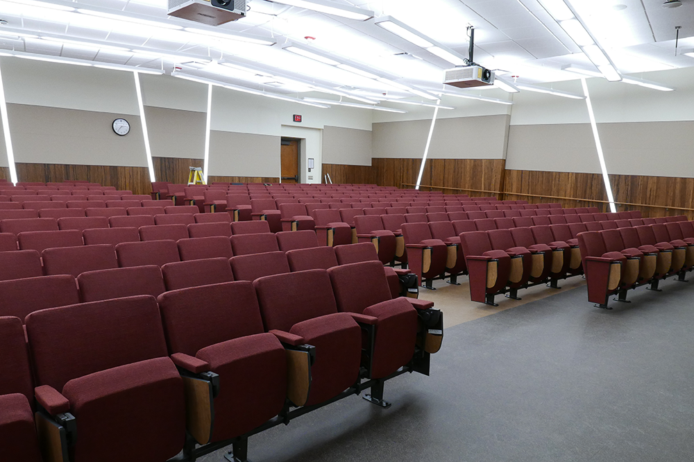 The NHB Auditorium is a large lecture hall that will seat 350 students, and there are plenty of allusions to geology all around for those who examine it closely. The painted stripes, wood paneling, and LED lighting design on the walls is meant to emulate the layers of the earth’s crust.