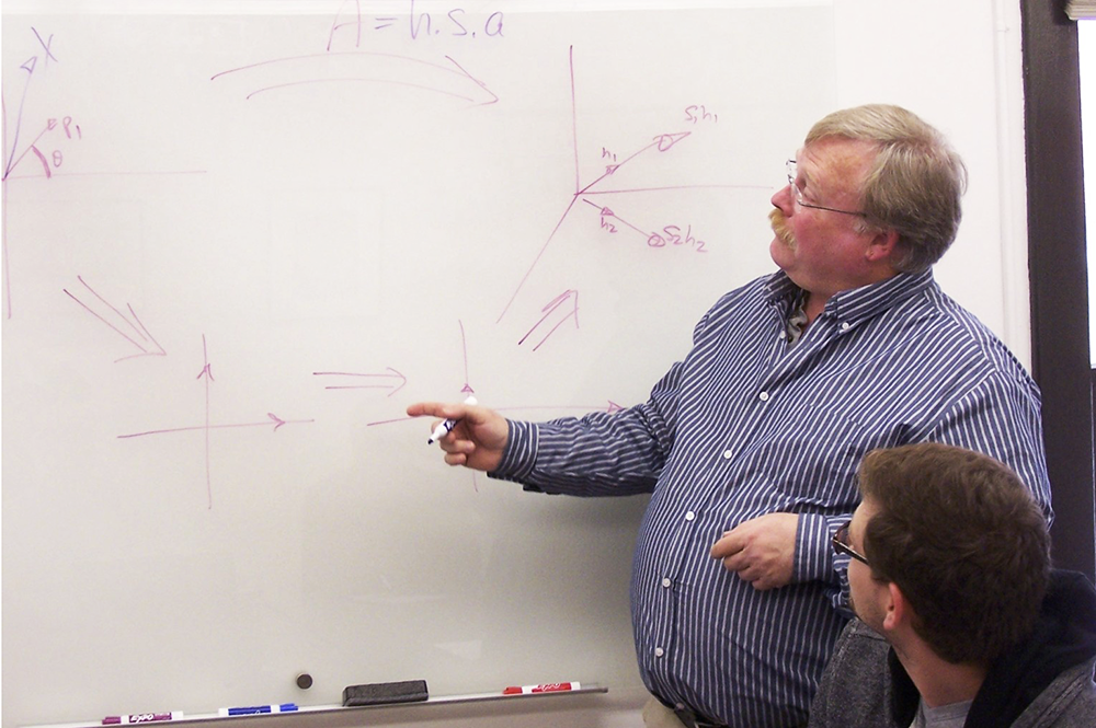 Bruce Carpenter, standing, associate director of instruction for NetMath, speaks to Matthew Garcia, a student who also worked as a mentor in the distance-learning program. (Photo courtesy of NetMath.) 
