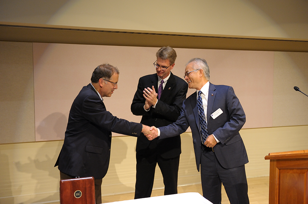 Andrew A. Gewirth, left, the Peter C. and Gretchen Miller Markunas Professor of Chemistry, is congratulated by Feng Sheng Hu, Harry E. Preble Dean of the College of LAS, right, and Vice Provost William Bernhard. (Thompson-McClellan.) 