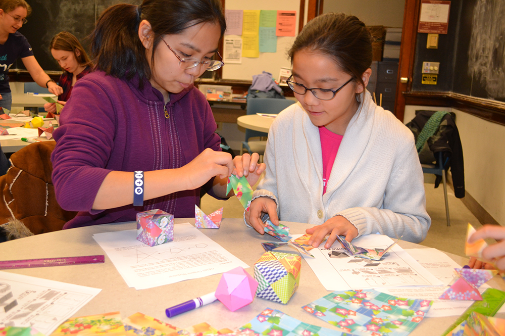 Sisters Jeana (left) and Grace To use mathematical principles to create origami shapes during an event hosted by the award-winning U of I chapter of the Association for Women in Mathematics. (Photo courtesy of AWM.)  